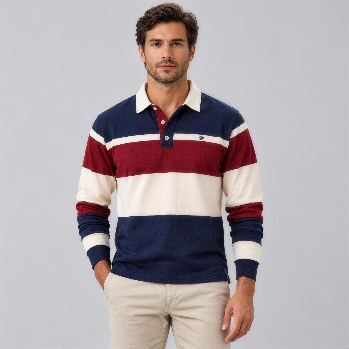 Man wearing the navy, burgundy and cream striped rugby knit polo with chinos, studio photo