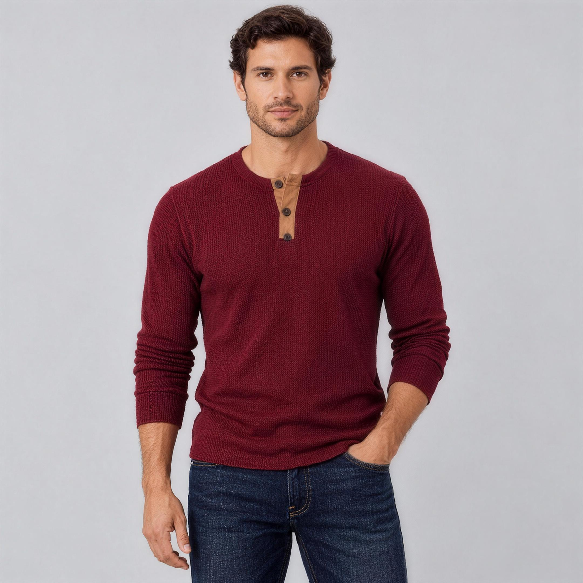 Man wearing the burgundy waffle knit henley with dark jeans, studio photo